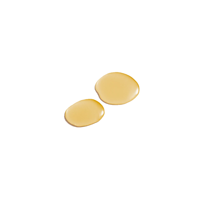 Two small, glossy droplets of golden-yellow oil on a solid white background.
